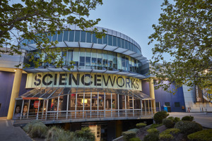 The entry to Scienceworks, with trees and plants in the foreground and ‘SCIENCEWORKS’ emblazoned above the entry.
