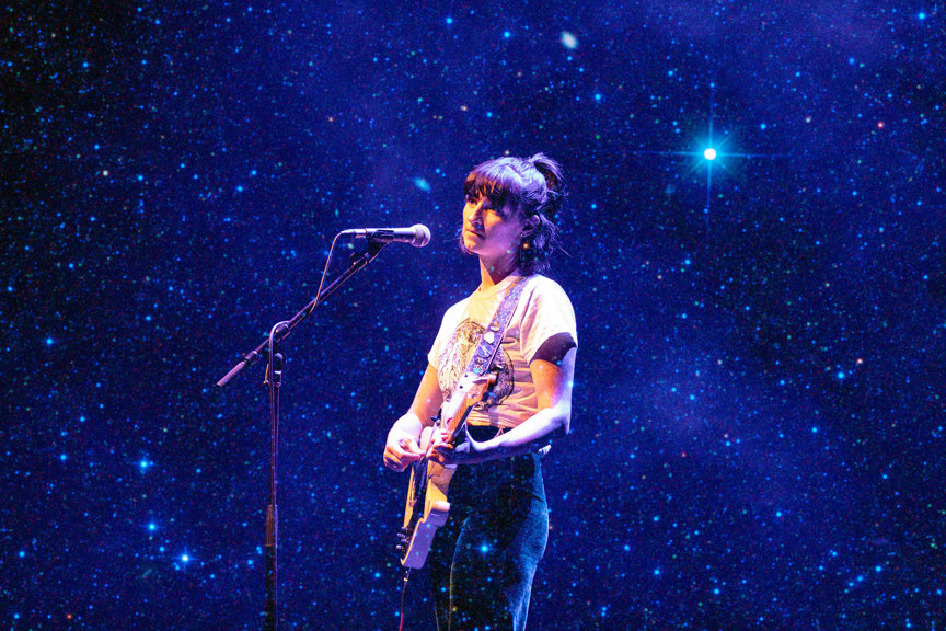 Woman on stage playing a guitar