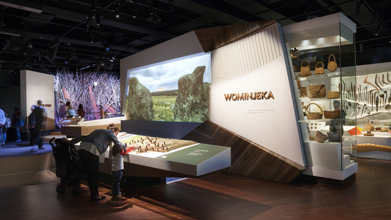 Exhibition entry with visitors looking at language map