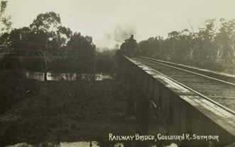 A steam locomotive crossing a rail bridge over the Goulburn River, Seymour, circa 1915