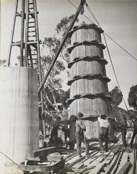 Workers guiding timber formwork into place as it is lifted by a crane during construction of the rail bridge over the Murray River, Yarrawonga, on the Yarrawonga to Oaklands line