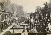 Testing the rail bridge over the Murray River, on the Strathmerton to Tocumwal line, Tocumwal, 1906. Workers are riveting steel strengthening plates along the top chord of the lattice girders.
