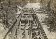 Constructing the bridge over the Murray River on the Strathmerton to Tocumwal line, Tocumwal, 1906. Workers are reinstating the timber decking following strengthening of steel work.