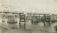 Construction of the Mitchell River Bridge, Bairnsdale, on the Bairnsdale to Orbost line, circa 1914. The road bridge over the Mitchell River is in the foreground.