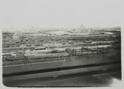 Spencer Street Station, post-1910. Covered railway platforms and railway yards. A large number of goods carriages in background. Railway line closest to covered platforms has been electrified.