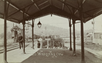 A guard stands on the platform of Wodonga Railway Station as a train approaches, circa 1910