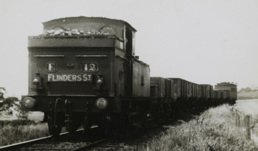 E class steam locomotive no. 12 bound for Flinders Street, hauling goods trucks, Heyington, circa 1921