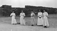 Women standing in front of a grain stack, Rainbow Station yard, circa 1910