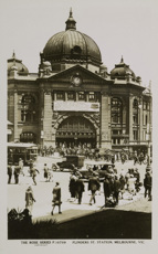 A large banner advertising Mt Buffalo Chalet spans the front of Flinders Street Railway Station, circa 1920