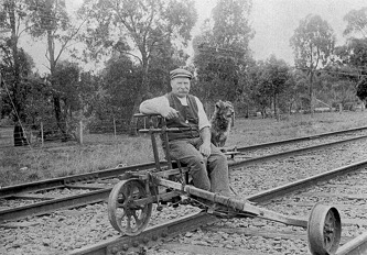 A ganger and a dog sitting on a ganger's trolley, Hastings district, circa 1920