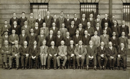 55 members of the Railway Construction Branch grouped outside the Victorian Railways Administration Building on Spencer Street, 1932