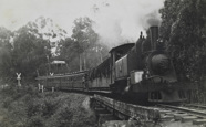 Steam locomotive hauling passenger carriages, circa 1920