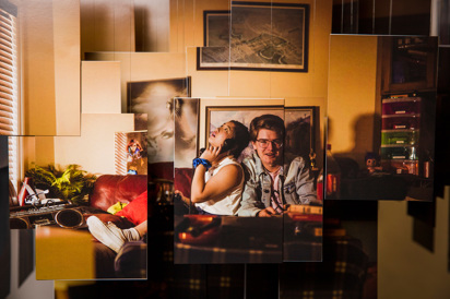A collage of multiple hanging photographs that depict a teenaged boy and girl sitting on a couch. She is talking on a rotary dial phone, while he is playing a video game. 