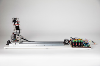 Side view of robotic arm, made of clear acrylic, with circuit boards and electrical components visible