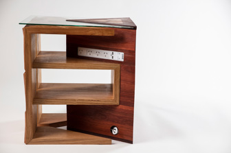A side view of the table. Three shelves are stacked to create a square table. It has a glass top. A powerboard and electrical plug can be seen 