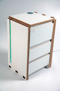 A white and wooden desk. The top of the desk is folded down alongside a set of three drawers. A strip of blue LED lights light the top of the desk. 