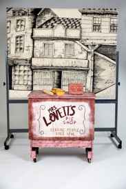 Theatre Props including backdrop on a whiteboard and table with smalled items on it