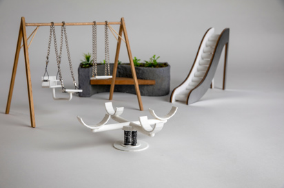 Close-up image of miniature swings, slide, merry-go-round and plant feature