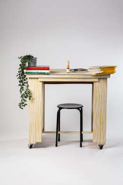 Prop of a desk with a stool and plant and books on top