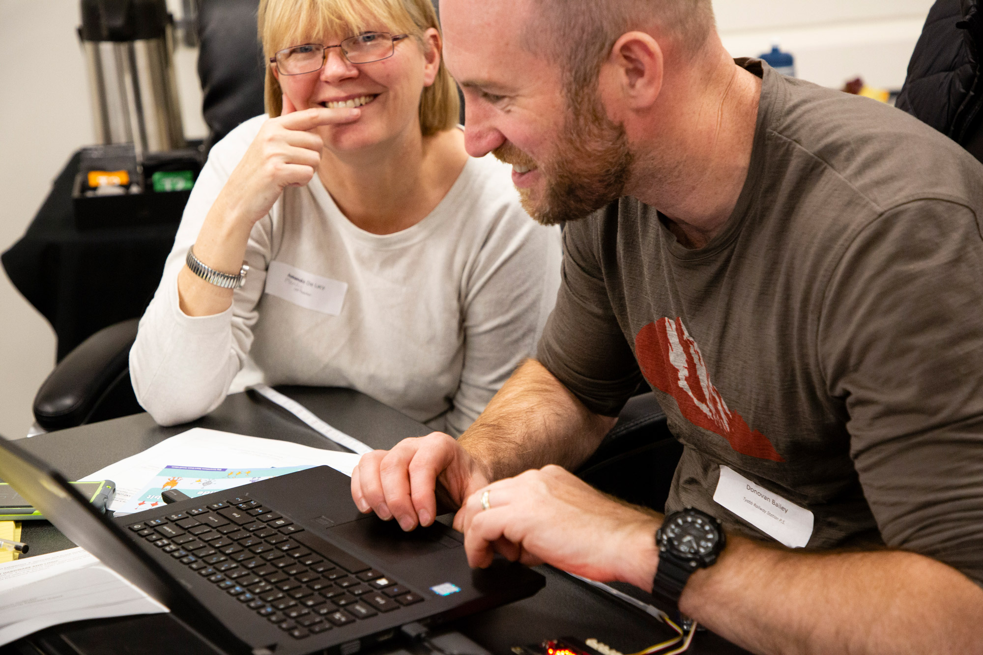 A woman and a man working together in front of a laptop