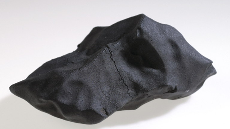 A large, smooth surfaced black rock.