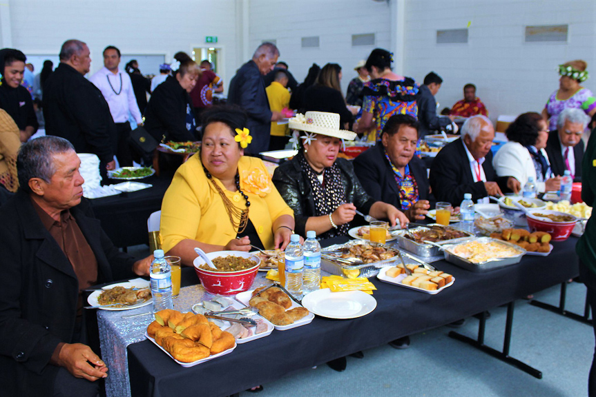 People eating at a long table with platters of food