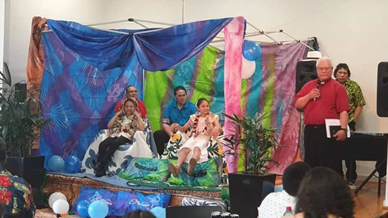 Four people on a stage draped with colourful cloth