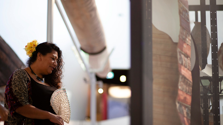 Woman holding a fan, she is viewing an exhibition