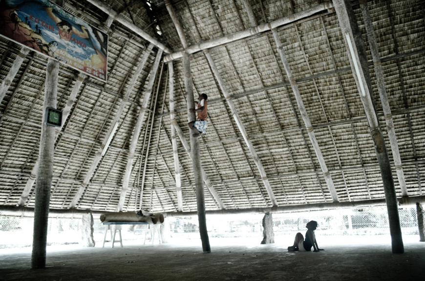 Man climbing a supporting pole to fix the roof