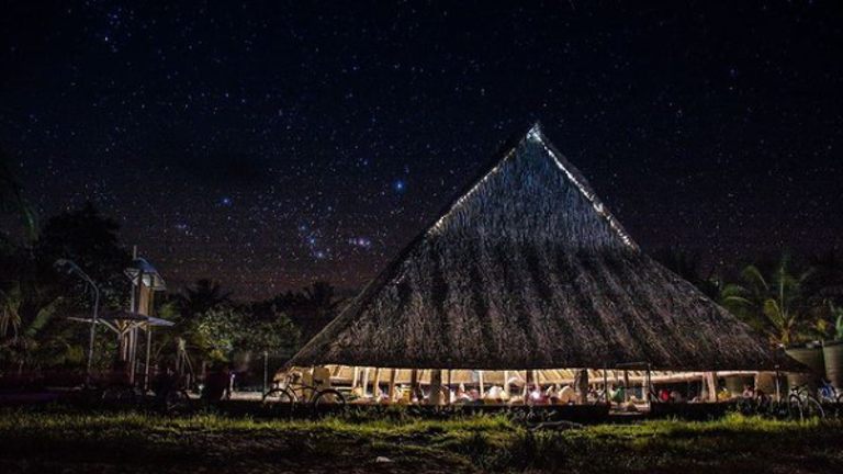 High thatched roof structure without walls at night time