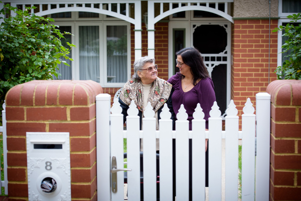 Two women standing behind a fence