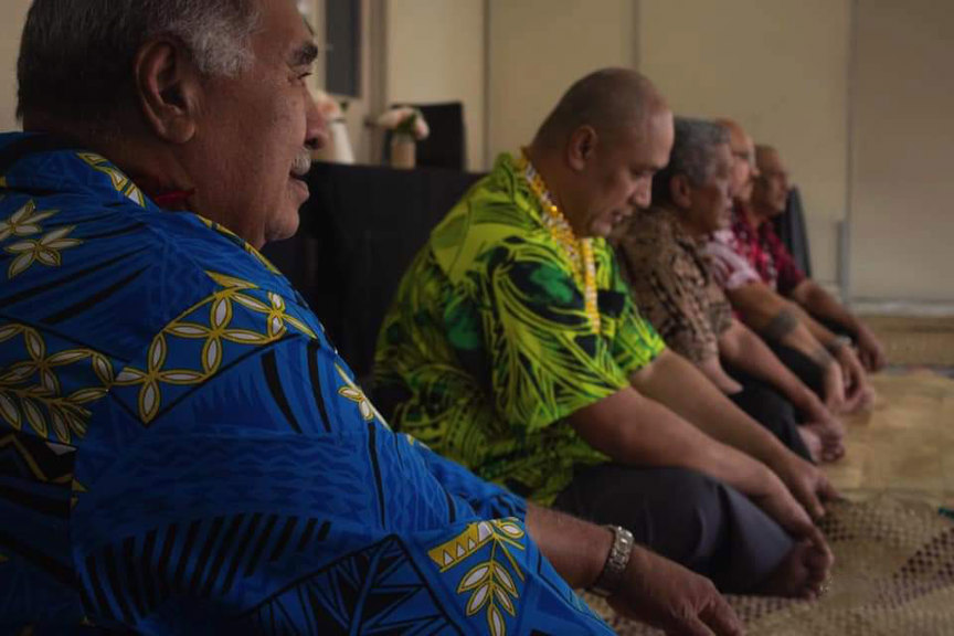 Men sitting cross legged in a row