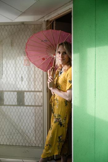 Woman with a parasol standing in a doorway