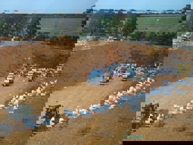 Land fill pit. Seagulls and large machine can be seen in the picture
