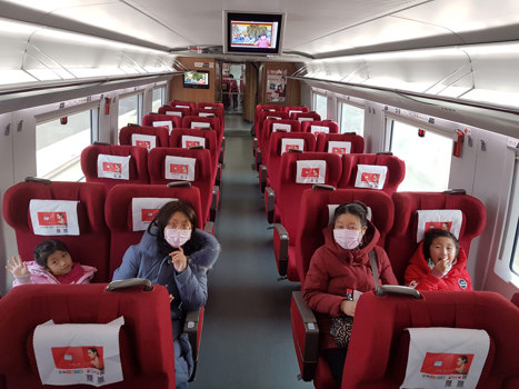 Four people sitting in a train. There is no one else in the carriage