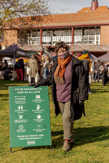 Woman standing next to a COVID sign