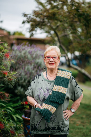 Woman standing in the garden with a scarf over her left shoulder