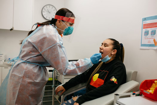 Woman preform a covid test on a female patient