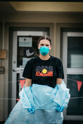 Woman wearing PPE displaying a "Always was always will be" t-shirt