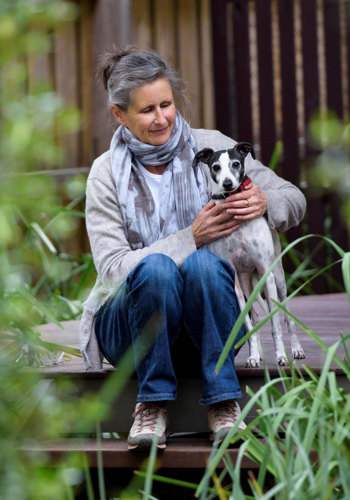 Woman sitting on the front step with her dog