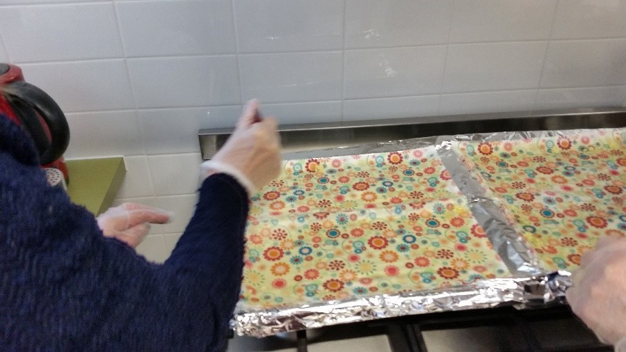 Detail of fabric covered with melted beeswax on oven trays