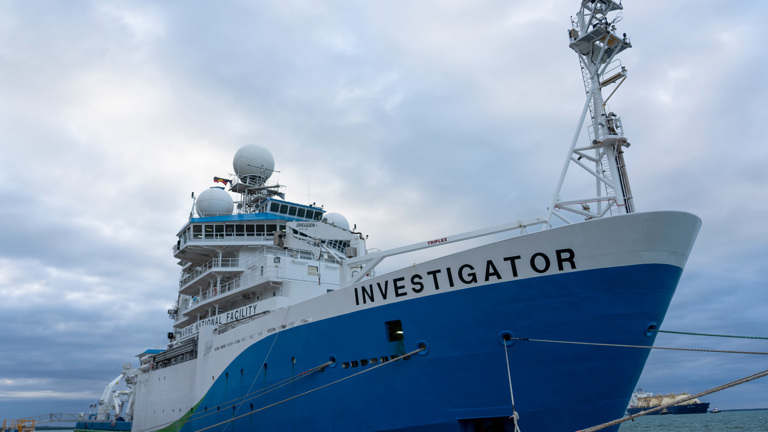 Large blue and white ship at the docked