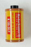 Cylindrical, terracotta-coloured metal film cartridge with label printed in red and yellow colour scheme. 