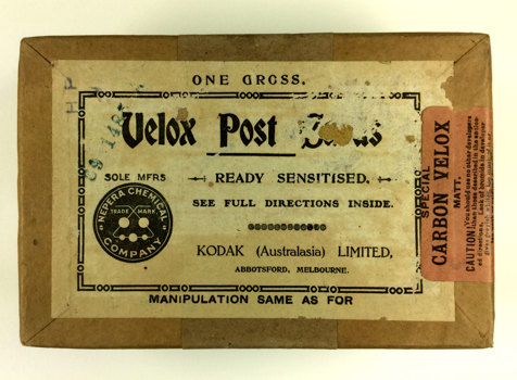 Brown thick cardboard box, with a white label and orange sticker