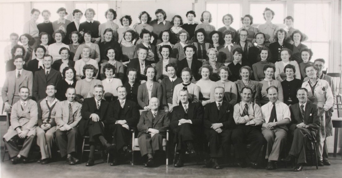 Black and white group photograph feature five rows of men and women