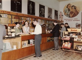 People in a shop that sells cameras, film and photographic equipment.