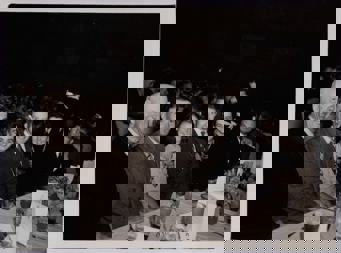 Group of men and woman sitting at long function table