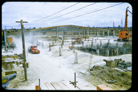 Trucks and crane on construction site.