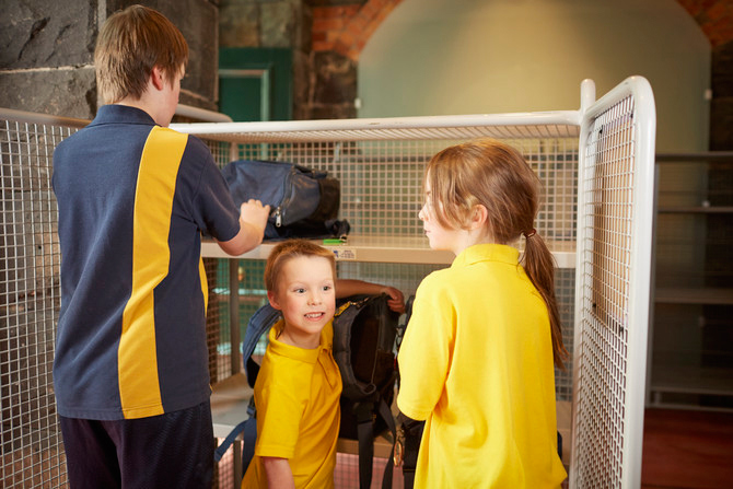 School children putting bags away at Immigration Museum.