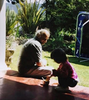Man and small child sitting on veranda.